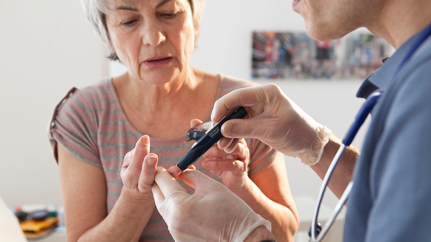 Ein Arzt nimmt einer Diabetes Patientin Blut ab.